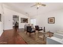 Open living room with hardwood floors, vaulted ceilings, contemporary furniture and a glimpse into the dining area at 15805 W Morning Glory St, Goodyear, AZ 85338