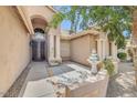 A stucco home featuring an arched doorway, pillars, decorative glass front door and desert landscaping at 16219 S 14Th Way, Phoenix, AZ 85048