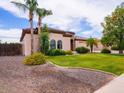Beautifully landscaped front yard with lush green grass, mature trees, and colorful flowerbeds at 20439 E Palomino Dr, Queen Creek, AZ 85142
