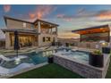 A luxurious backyard boasts a pool, spa, outdoor kitchen, covered patio, and desert views at 21632 W Hillcrest Blvd, Buckeye, AZ 85396