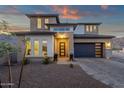 Beautiful home showcasing a modern design with desert landscaping, a gray garage door, and large windows at 21632 W Hillcrest Blvd, Buckeye, AZ 85396