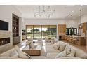 Spacious living room with modern lighting, fireplace, and backyard views at 23002 N Country Club Trl, Scottsdale, AZ 85255