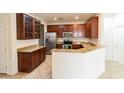 Spacious kitchen featuring granite countertops, stainless steel appliances, and dark wood cabinetry at 25640 N 108Th Dr, Peoria, AZ 85383