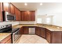 Modern kitchen with stainless appliances, granite countertops, and tile flooring at 25640 N 108Th Dr, Peoria, AZ 85383