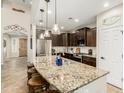 Spacious kitchen featuring granite counters, stainless appliances, and stylish pendant lighting over a large island at 26391 N 107Th Dr, Peoria, AZ 85383