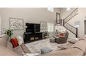Open concept living room with staircase, large sectional, and tall ceilings at 26391 N 107Th Dr, Peoria, AZ 85383