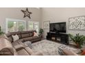 Bright living room featuring high ceilings, a large sectional, and plentiful windows at 26391 N 107Th Dr, Peoria, AZ 85383