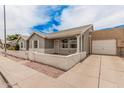 Home featuring a decorative brick wall, a garage, and mature landscaping at 2929 E Broadway Rd # 30, Mesa, AZ 85204