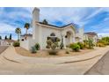 An exterior view of a bright white home with desert landscaping, and mature palm trees at 3315 E Taro Ln, Phoenix, AZ 85050