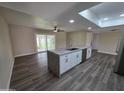 Spacious open kitchen with a large island, stainless steel appliances, and wood-look floors at 3849 W Mauna Loa Ln, Phoenix, AZ 85053