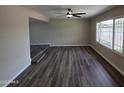Sunlit living room featuring new wood-look floors and a ceiling fan at 3849 W Mauna Loa Ln, Phoenix, AZ 85053