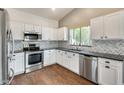Bright kitchen featuring white cabinets, stainless steel appliances, granite countertops, and a stylish backsplash at 4041 W Hackamore Dr, Phoenix, AZ 85083