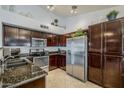 Modern kitchen featuring stainless steel appliances, granite countertops, and dark wood cabinetry at 4407 W Avenida Del Sol --, Glendale, AZ 85310