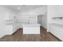 Bright kitchen features white cabinets, stainless steel sink, and an island at 471 W Gascon Rd, San Tan Valley, AZ 85143