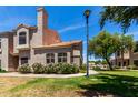 Exterior view showing manicured lawn, mature trees, and architectural detail at 500 N Roosevelt Ave # 26, Chandler, AZ 85226