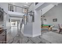 Grand foyer with marble flooring, modern staircase, and an adjacent recreation room at 5020 E Dallas St, Mesa, AZ 85205