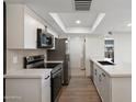 Well-lit kitchen featuring stainless steel appliances, white cabinets, and a quartz countertop, with easy access to a utility room at 520 N Stapley Dr # 166, Mesa, AZ 85203
