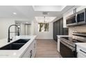 Bright kitchen with a stainless steel oven, and microwave, stylish white cabinets and countertops, and view of adjacent room at 520 N Stapley Dr # 166, Mesa, AZ 85203
