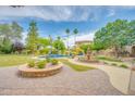 Resort-style backyard featuring a pool, fountain, outdoor bar, and lush green landscaping at 700 N Dobson Rd # 34, Chandler, AZ 85224