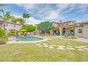 Beautiful backyard showcasing a sparkling pool, lush green lawn, fountain, and lounge areas at 700 N Dobson Rd # 34, Chandler, AZ 85224