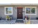 Charming home entrance featuring a decorative security door, stylish address numbers, and welcoming plants at 7135 W Flower St, Phoenix, AZ 85033