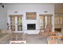 Bright living room boasts a fireplace, French doors, neutral color palette and carpet at 9130 W Utopia Rd, Peoria, AZ 85382