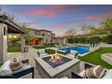 Expansive backyard with a pool, fire pit, and covered patio, perfect for outdoor entertaining and relaxation at 9939 E Desert Jewel Dr, Scottsdale, AZ 85255