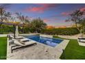 Relaxing poolside featuring comfortable lounge chairs, well-maintained turf, and a peaceful ambiance at 9939 E Desert Jewel Dr, Scottsdale, AZ 85255