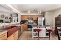 The kitchen features wooden cabinetry, stainless steel appliances, and a kitchen island at 12606 W Scotts Dr, El Mirage, AZ 85335