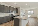 New kitchen with stainless appliances, white subway tile, wood flooring and island at 12816 N 172Nd Dr, Surprise, AZ 85388