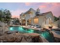 Luxurious pool with beautiful rock features, built-in spa, a tanning ledge, and an elegant outdoor living space at 13250 N 13Th Ln, Phoenix, AZ 85029