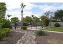 Lush backyard showcasing a wrought iron fence, mature landscaping and desert landscaping at 13486 W Evans Dr, Surprise, AZ 85379