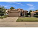 A well-maintained home boasts lush landscaping, terracotta tile roofing, and a welcoming two-car garage at 1558 W Maplewood St, Chandler, AZ 85286