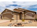 Single-story home with a two-car garage, desert landscaping, and rock accents at 15980 W Smokey Dr, Surprise, AZ 85374