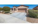 View of the driveway leading to a house with well-kept landscaping and a two-car garage at 17111 S 180Th Ln, Goodyear, AZ 85338