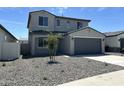 Inviting two-story home featuring a gray exterior, two-car garage, and low-maintenance gravel landscaping at 17245 W Corrine Dr, Surprise, AZ 85388