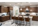 Open concept kitchen features an island with bar seating, stainless steel appliances, and ample cabinet space at 17312 W Dahlia Dr, Surprise, AZ 85388