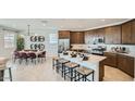 Open-concept kitchen with stainless appliances, large island with seating, and an adjacent dining area at 23081 E Saddle Way, Queen Creek, AZ 85142