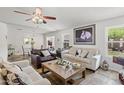 Bright living room featuring neutral-toned sofas, horse artwork, ceiling fan, and slate tile flooring at 3605 W Pecos Rd, Chandler, AZ 85226