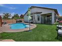 Private backyard showcasing a refreshing pool, artificial turf, and outdoor seating area at 3812 W Carlos Ln, San Tan Valley, AZ 85144