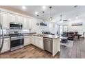 Stylish kitchen open to the living area features granite countertops, stainless appliances, and wood flooring at 4218 W Palace Station Rd, New River, AZ 85087