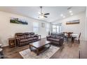 Inviting living room features wood-look tile flooring, a ceiling fan, and sliding glass doors to the backyard at 4218 W Palace Station Rd, New River, AZ 85087