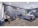 Relaxing bedroom space featuring recessed lighting, hardwood floors, and a hanging swing chair at 45574 W Tulip Ln, Maricopa, AZ 85139