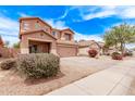 Two-story home features a two-car garage, a cozy front porch and colorful flowering bushes at 45574 W Tulip Ln, Maricopa, AZ 85139