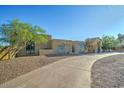 Inviting desert home with a circular driveway, desert landscaping, and a covered entry at 6519 E Cactus Rd, Scottsdale, AZ 85254