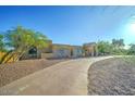 Attractive desert home features a circular driveway, stucco walls, and a covered entryway at 6519 E Cactus Rd, Scottsdale, AZ 85254