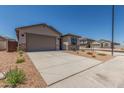 Charming home featuring a gray stucco exterior, blue shutters, desert landscaping and a large two car garage at 7229 E Cattle Call St, San Tan Valley, AZ 85143
