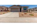 Charming home featuring a gray stucco exterior, blue shutters, desert landscaping and a large two car garage at 7229 E Cattle Call St, San Tan Valley, AZ 85143