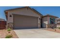 Charming home featuring a gray stucco exterior, blue shutters, desert landscaping and a large two car garage at 7229 E Cattle Call St, San Tan Valley, AZ 85143