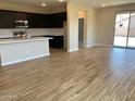 Open-concept living area featuring tile flooring, a modern kitchen, and sliding glass doors leading to the backyard at 7229 E Cattle Call St, San Tan Valley, AZ 85143